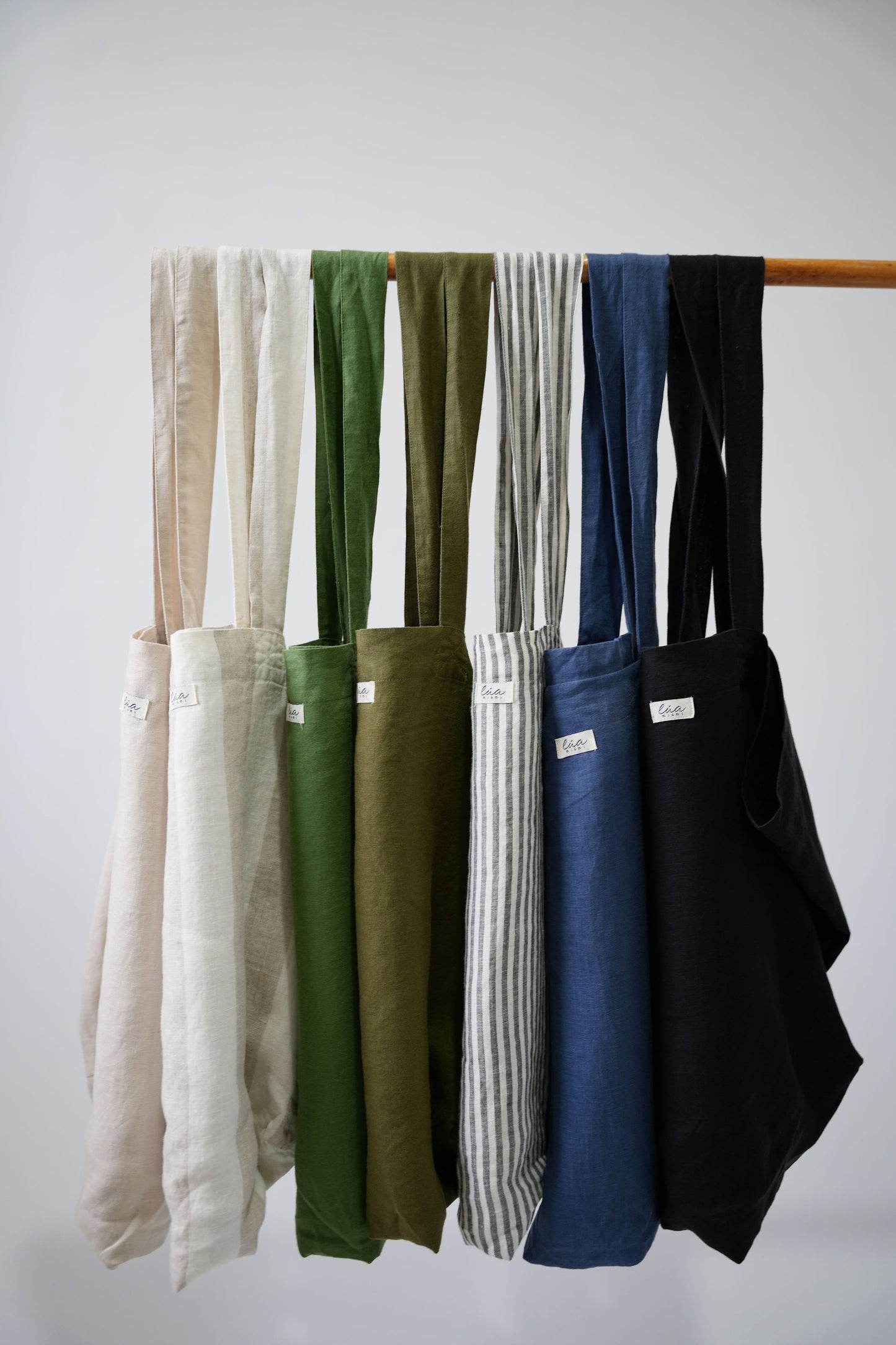 Natural linen tote bags, oversized, multiple colors, Lúa Miami logo detail, white studio background — Lúa Miami