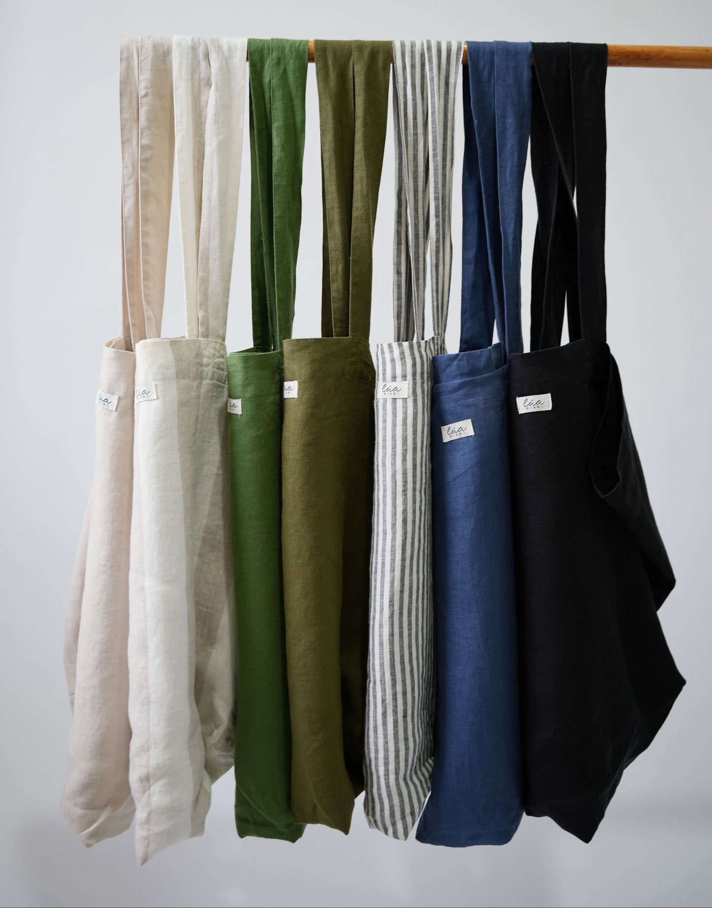 Natural linen tote bags, oversized, multiple colors, Lúa Miami logo detail, white studio background — Lúa Miami