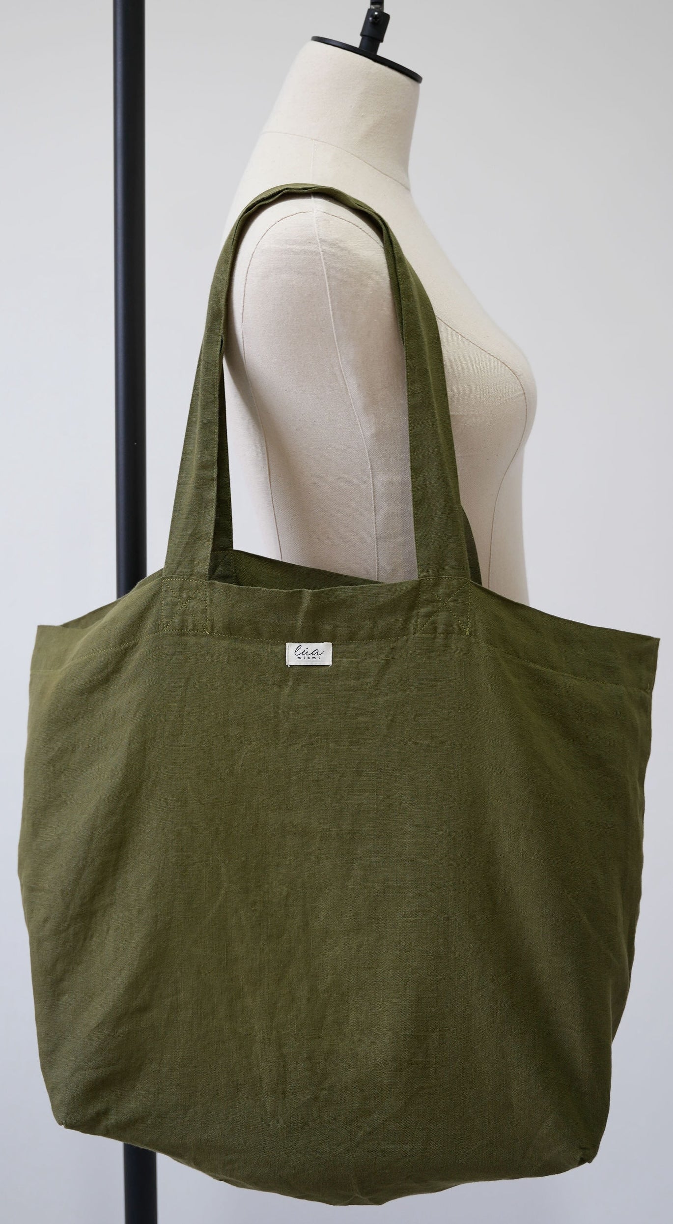 Natural linen tote bag, oversized, olive, Lúa Miami logo detail, white studio background — Lúa Miami