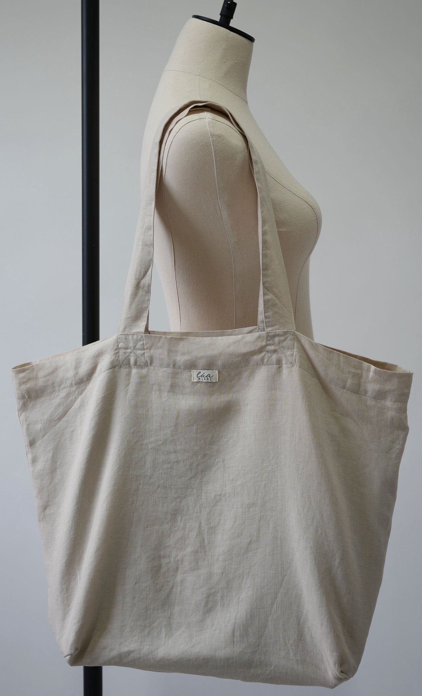 Natural linen tote bag, oversized, soft ivory, Lúa Miami logo detail, white studio background — Lúa Miami